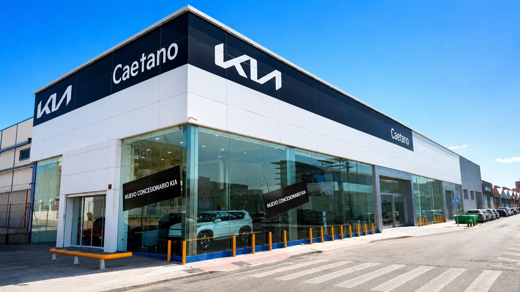 Fachada en esquina del nuevo concesionario Kia Caetano en Fuenlabrada, con el logotipo de Kia y el rótulo Caetano