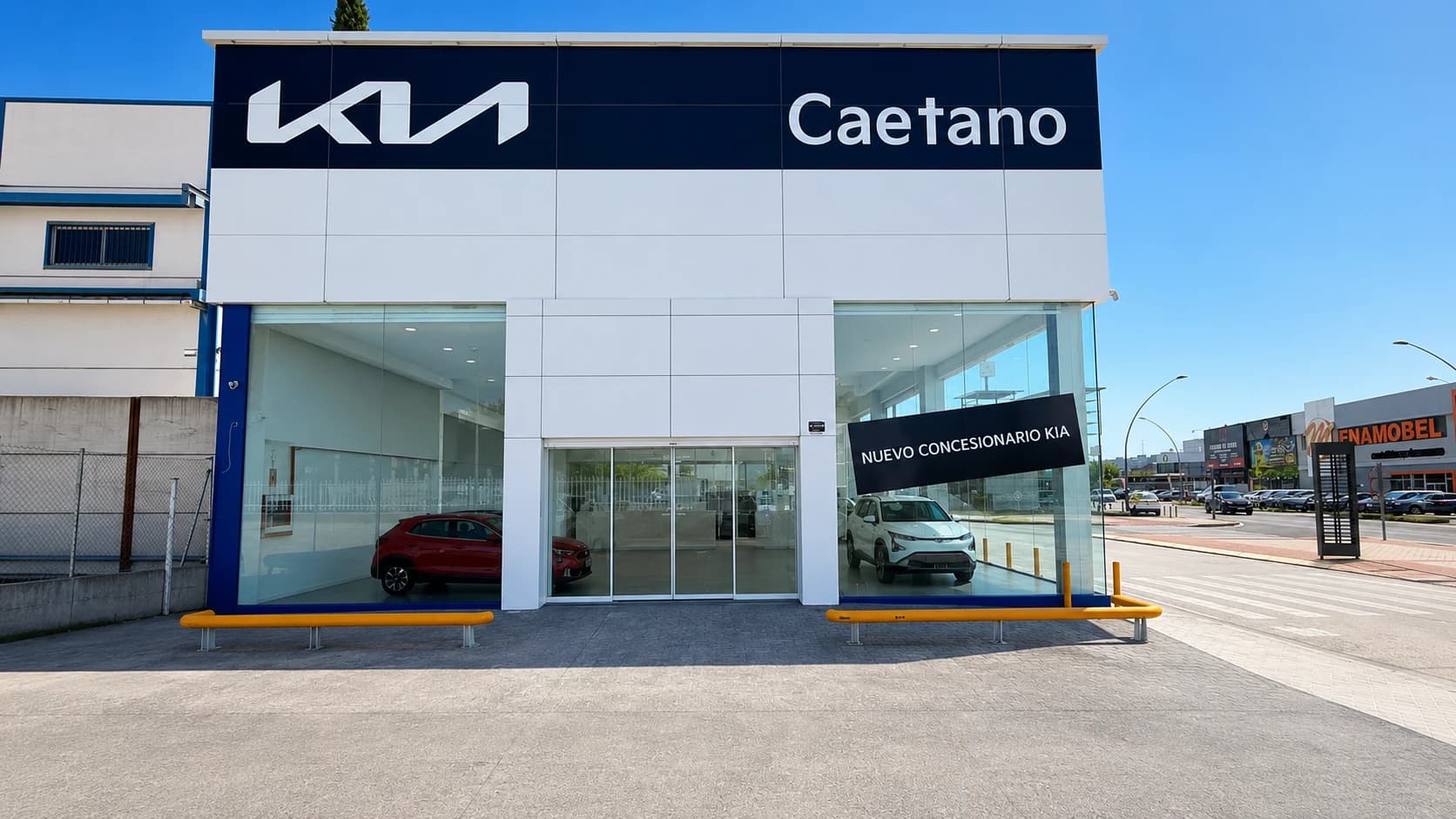 Frontal del concesionario Kia Caetano de Fuenlabrada con dos coches Kia expuestos tras el cristal