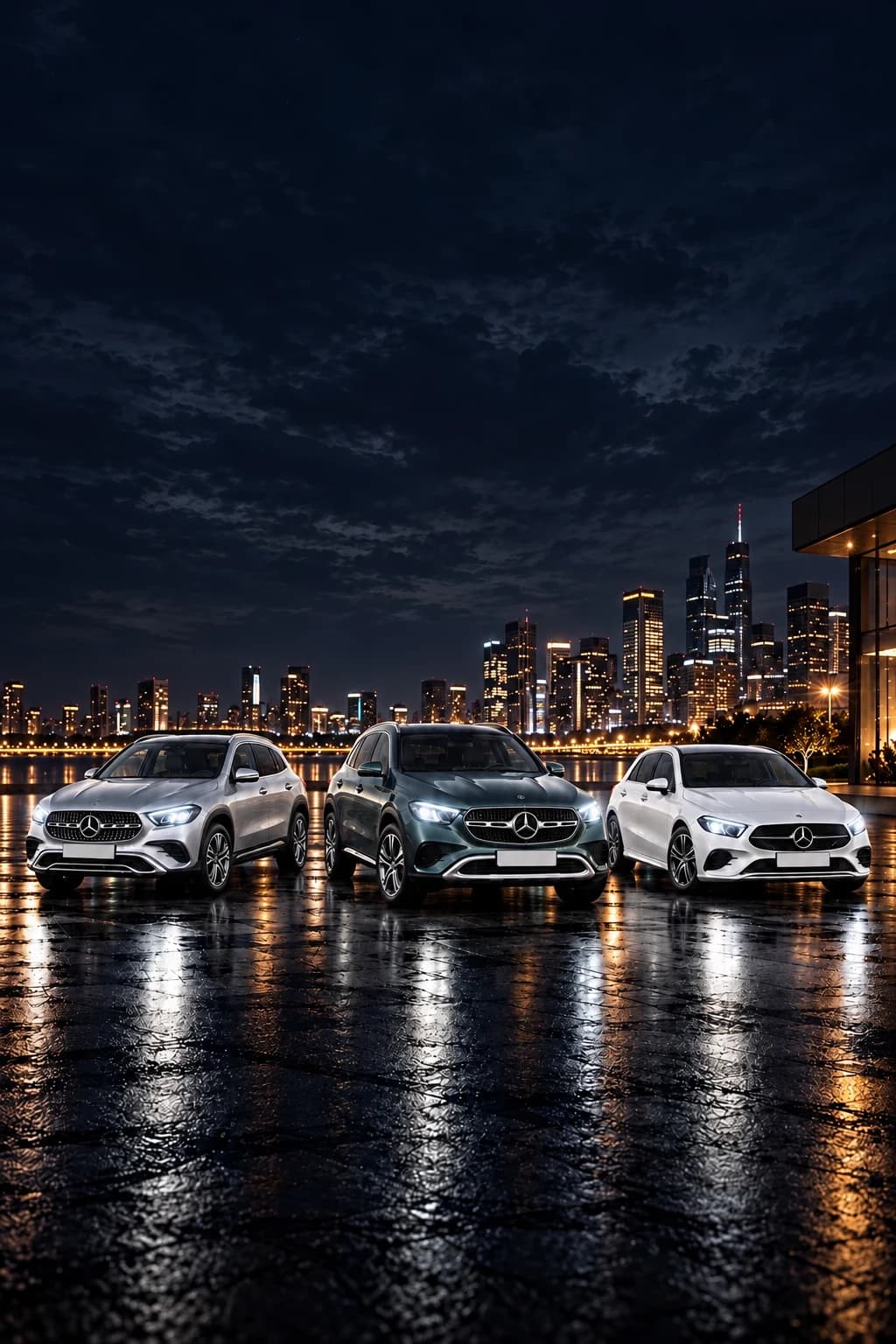 Mercedes-Benz GLA, GLC y Clase A aparcados de noche frente a una ciudad iluminada