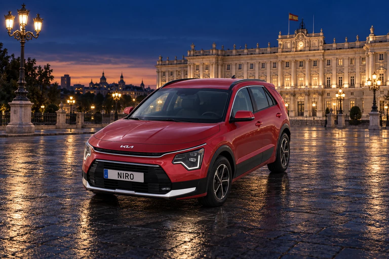 Kia Niro rojo con la matrícula NIRO al anochecer en una plaza de Madrid, con el Palacio Real iluminado al fondo