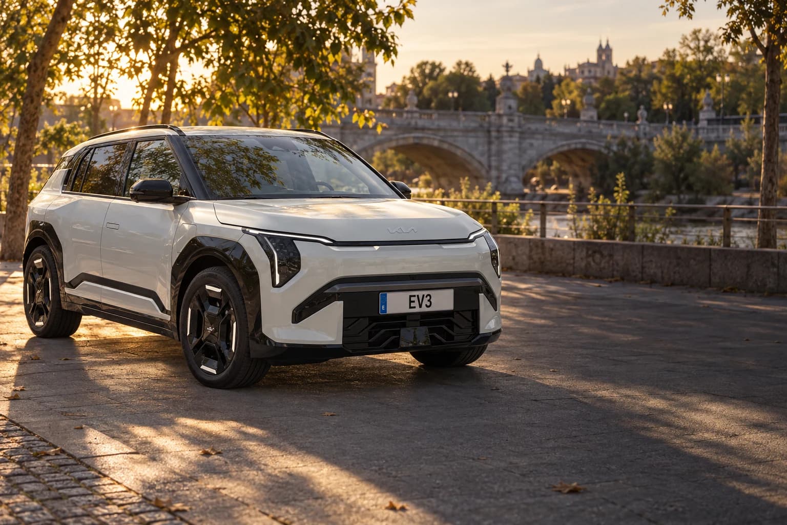 Kia EV3 GT-line plateado en Madrid Río junto al puente de Segovia al atardecer