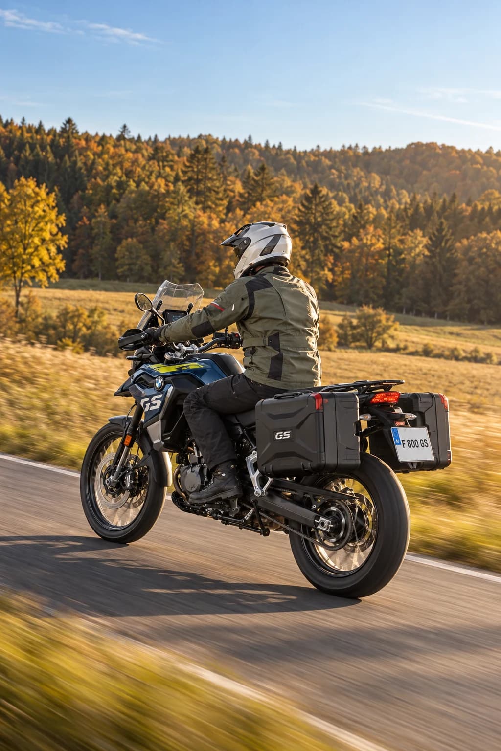BMW F 800 GS con maletas laterales circulando por una carretera rural en otoño