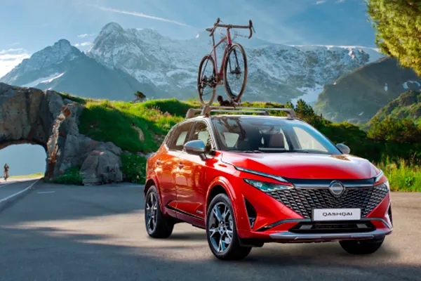 Nissan Qashqai rojo Foto montaje de un Nissan Qashqai rojo con una bicicleta en la baca del techo