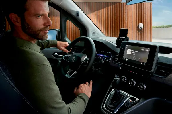Renault Kangoo Stock VO Interior Señor sentado en el Renault Kangoo con la pantalla encendida