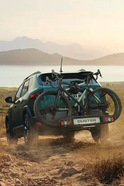 Daca Duster stock vo foto de un Dacia Duster en el campo con una bicicleta enganchada al maletero