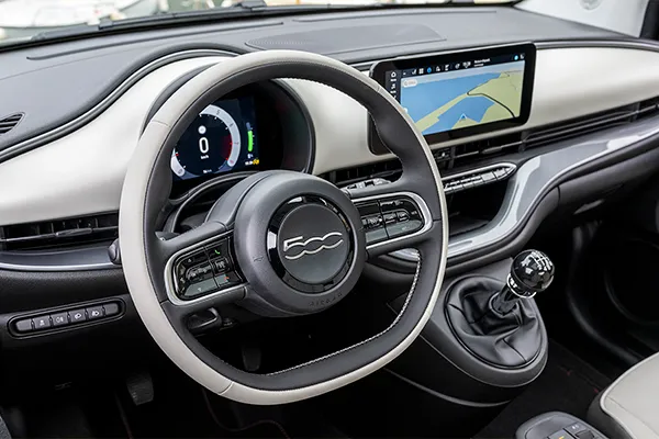 Foto del interior del Fiat 500 en el que se ven el volante y la palanca de cambios