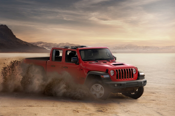 Jeep Gladiator de ocasión rojo Jeep Gladiator de ocasión rojo levantando arena en pista off-road al atardecer