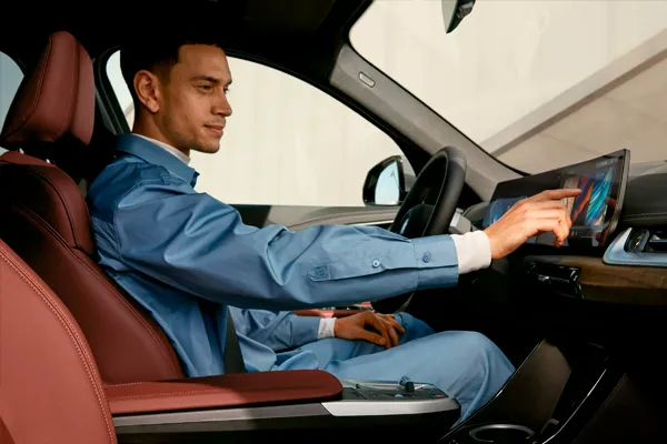BMW iX1 interior Hombre sentado en el interior de BMW iX1 tocando pantalla táctil