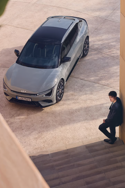 Joven junto a Kia EV6 de ocasión gris